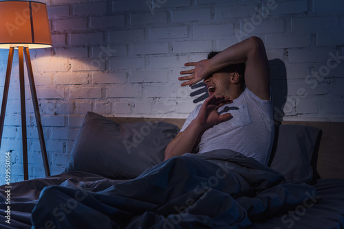 Bild auf Leinwand scared young man with ptsd having flashbacks while screaming at night
