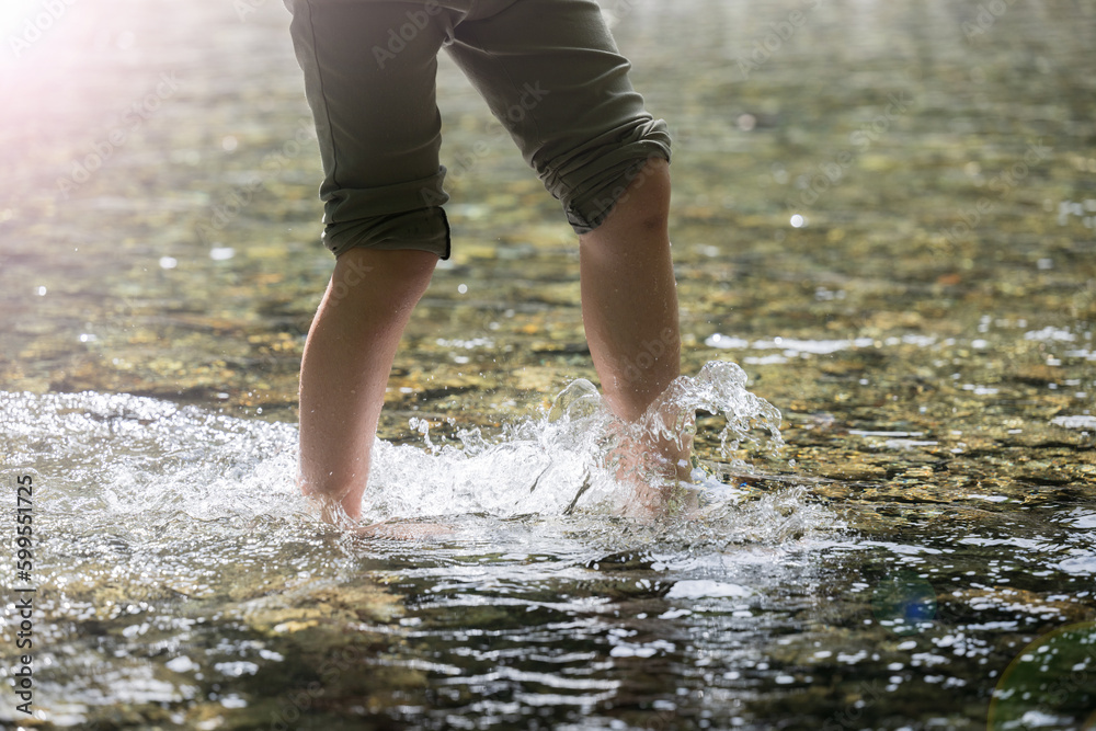 For summer leisure and outdoor activities. Children's feet playing in the water.