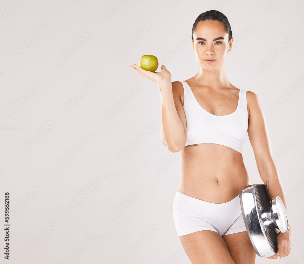 Fitness, health and woman with scale and apple for weightloss, diet and nutrition on white background. Exercise, wellness and girl with fruit, slim body and weight measurement for healthy lifestyle