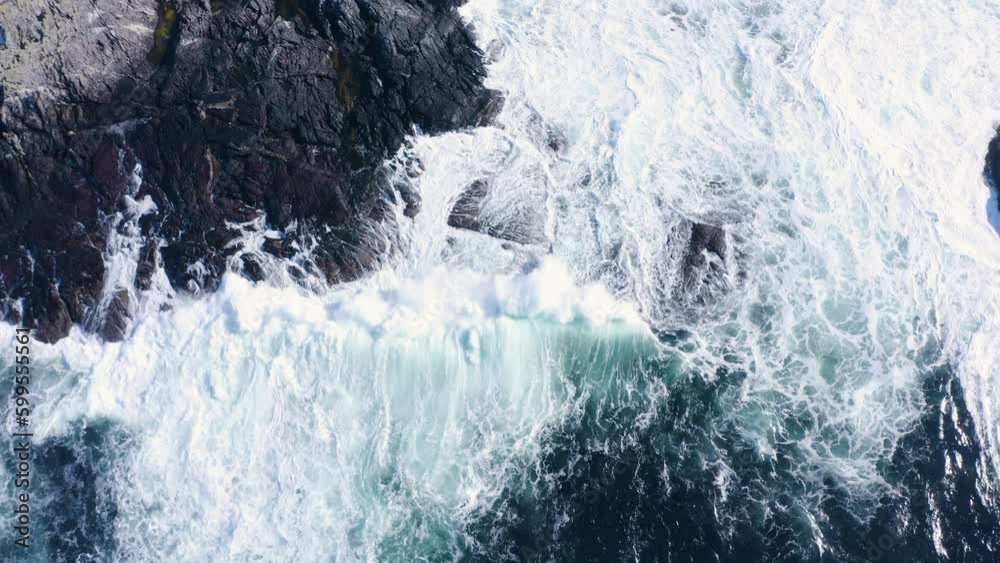Topdown aerial shot of waves building up and breaking as they hit the shore. Topdown aerial shot of waves building up and breaking as they hit the shore.