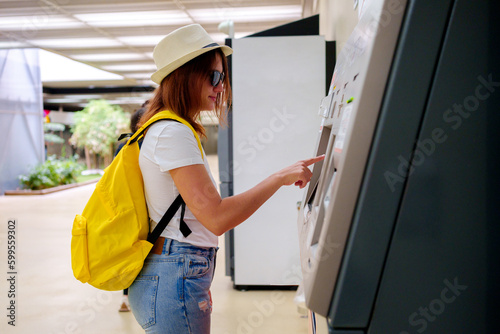 young traveler girl buys train ticket in the city