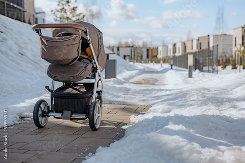 Baby stroller in winter. Tire tracks on snow. Infant baby sleep inside the pram on fresh air.