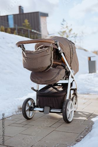 Baby stroller in winter. Tire tracks on snow. Infant baby sleep inside the pram on fresh air.