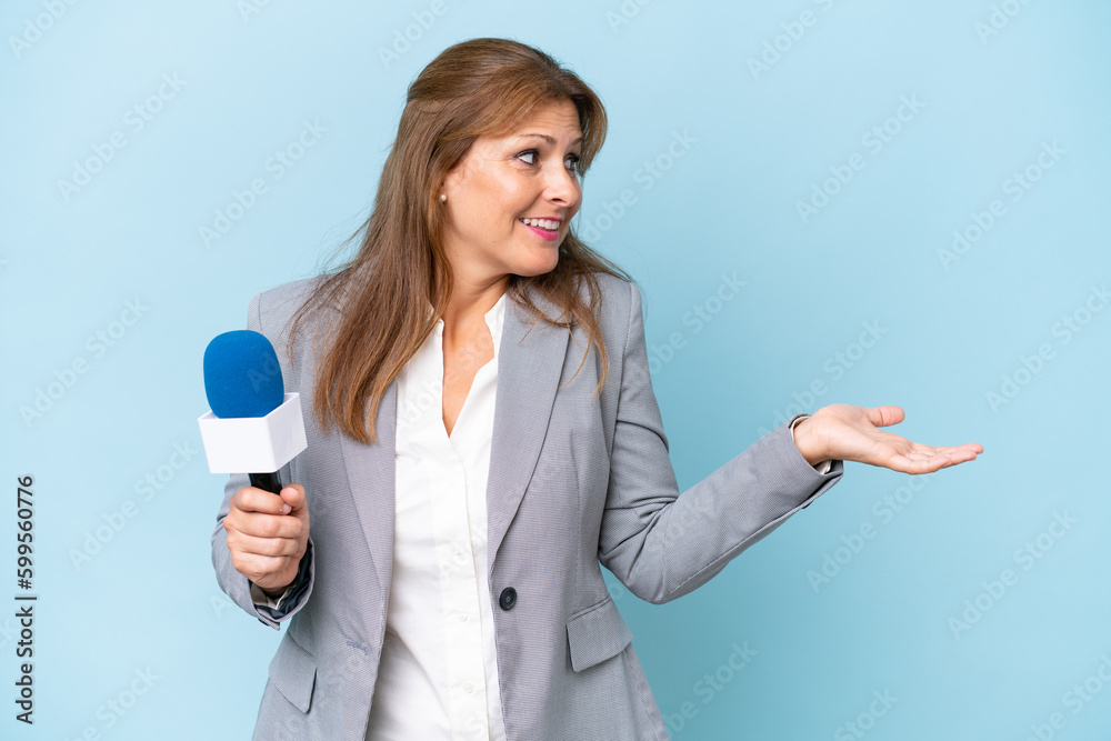 Middle-aged TV presenter woman over isolated blue background with surprise expression while looking side Middle-aged TV presenter woman over isolated blue background with surprise expression while looking side