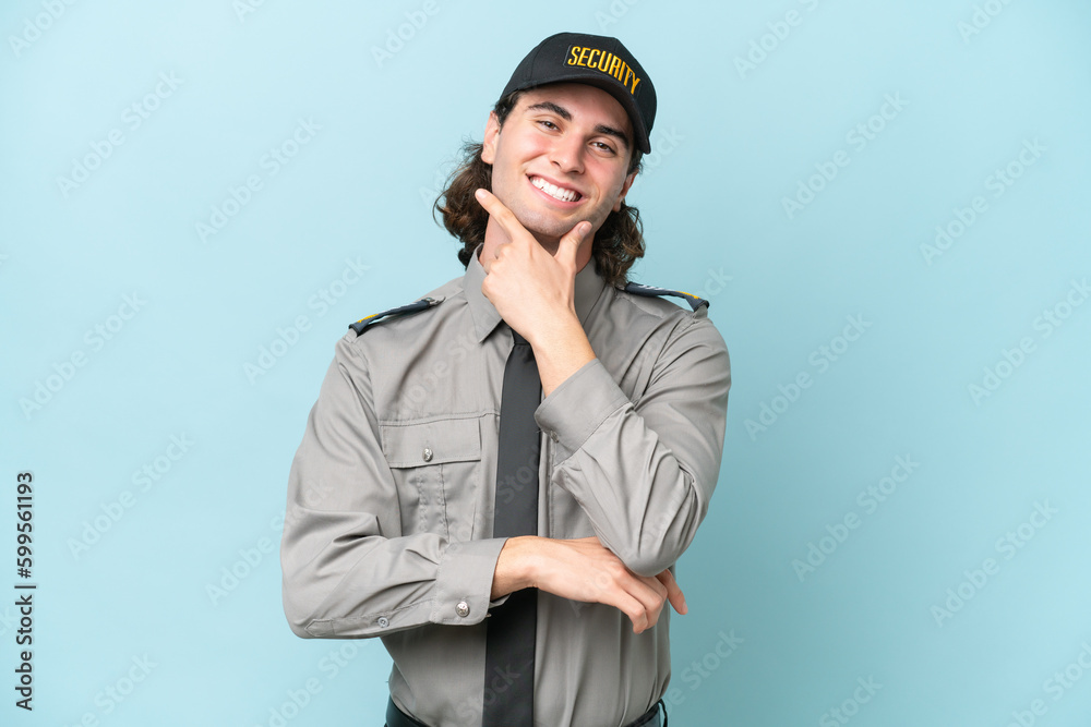 Young safeguard man isolated on blue background smiling Young safeguard man isolated on blue background smiling
