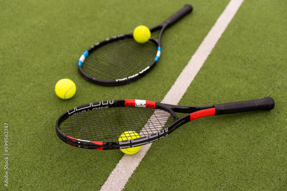 tennis racket with balls on green background.