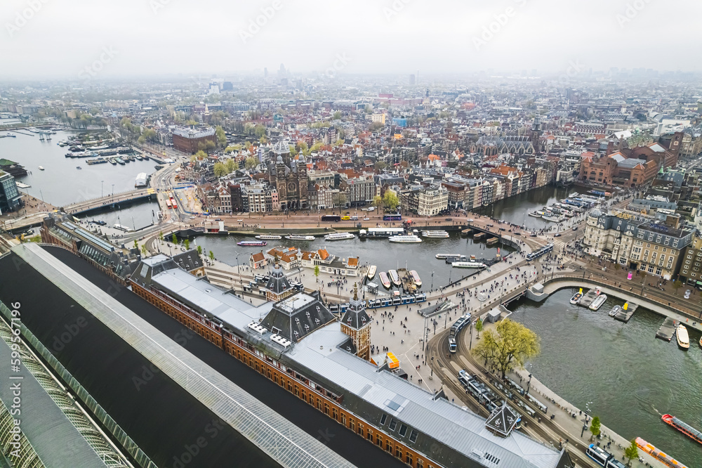 Canal cruise boat in front of Amsterdam central railway station in Amsterdam, Netherlands. drone shot. High quality photo