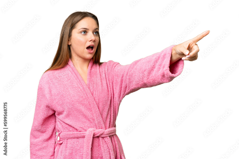 Young woman in a bathrobe over isolated chroma key background pointing away Young woman in a bathrobe over isolated chroma key background pointing away