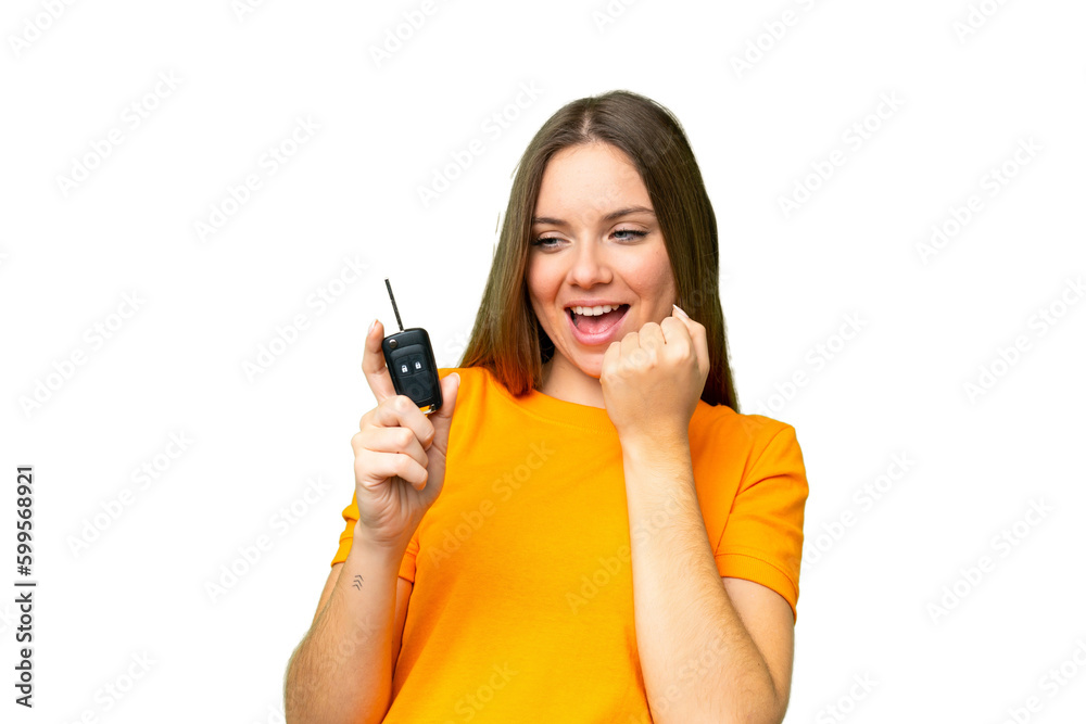 Young woman holding car keys over isolated chroma key background celebrating a victory