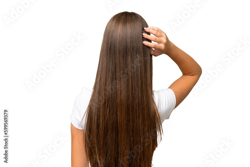Teenager caucasian girl over isolated background in back position and thinking