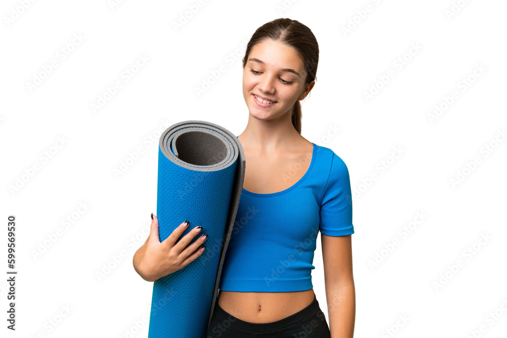 Teenager caucasian girl going to yoga classes while holding a mat over isolated background with happy expression Teenager caucasian girl going to yoga classes while holding a mat over isolated background with happy expression