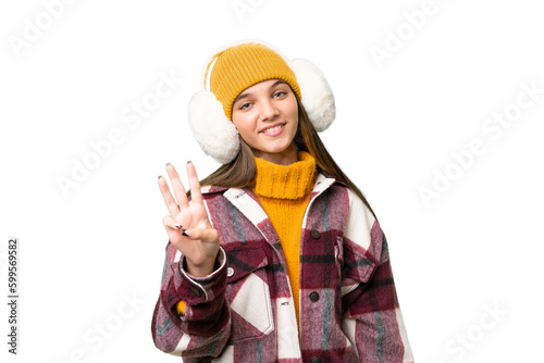 Teenager caucasian girl wearing winter muffs over isolated background happy and counting three with fingers