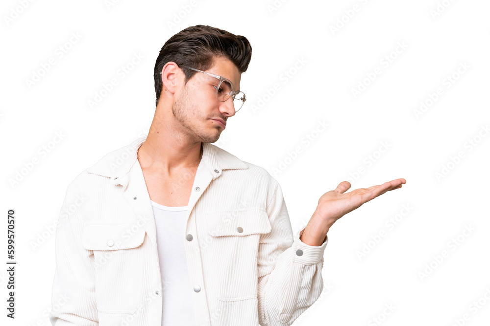Young handsome caucasian man over isolated background holding copyspace with doubts Young handsome caucasian man over isolated background holding copyspace with doubts