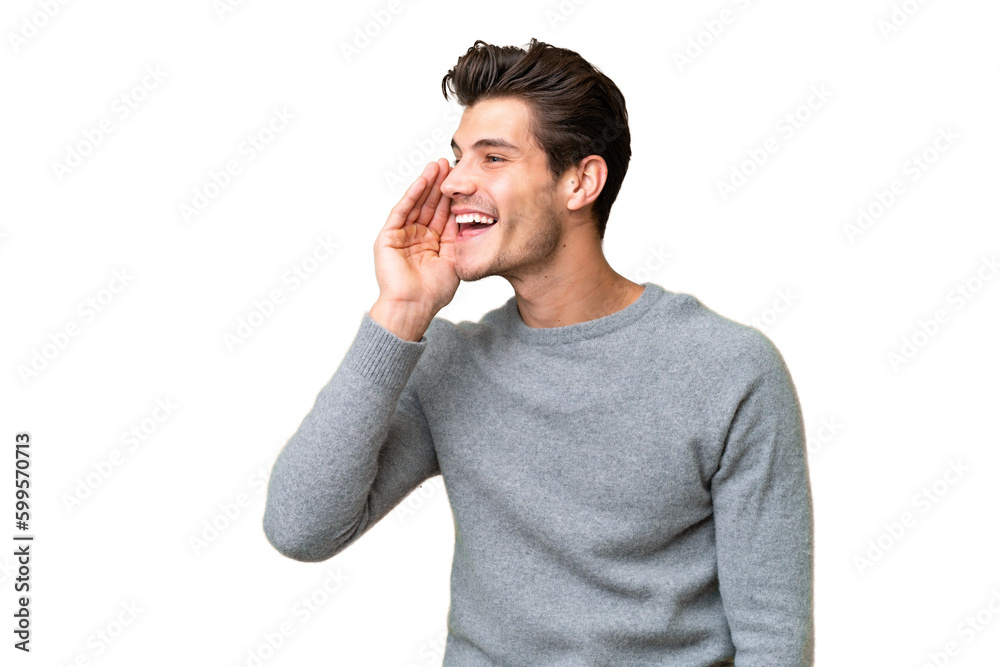 Young handsome caucasian man over isolated background shouting with mouth wide open to the lateral Young handsome caucasian man over isolated background shouting with mouth wide open to the lateral