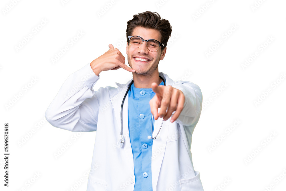 Young doctor man over isolated background making phone gesture and pointing front Young doctor man over isolated background making phone gesture and pointing front