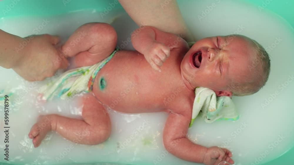 Wideo Stock A newborn baby. Newborn baby boy swimming in water. The