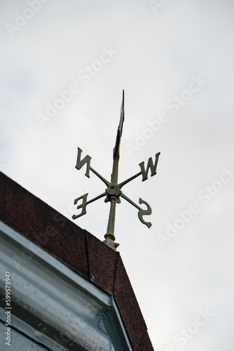 Rustic arrow Weather Vane with wind direction east, west, north and south. Weathervane on the roof