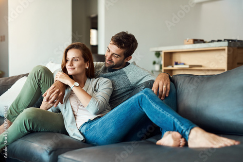 Our future looks really bright. Full length shot of an affectionate young couple relaxing on their sofa at home.