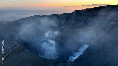 Sunrise at the top of Aso volcano, aerial view of smoke rising from the caldera of active volcano in Japan, Mount Aso volcano, volcanic landscape