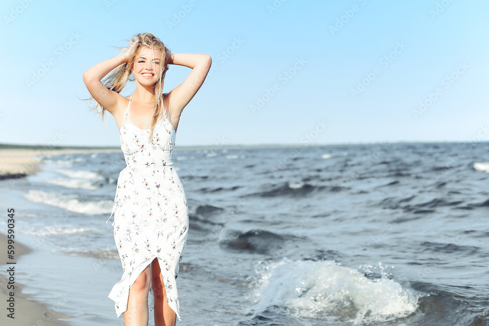Happy blonde woman wearing sun glasses and relaxing on a wooden deck chair at the ocean beach Happy blonde woman wearing sun glasses and relaxing on a wooden deck chair at the ocean beach