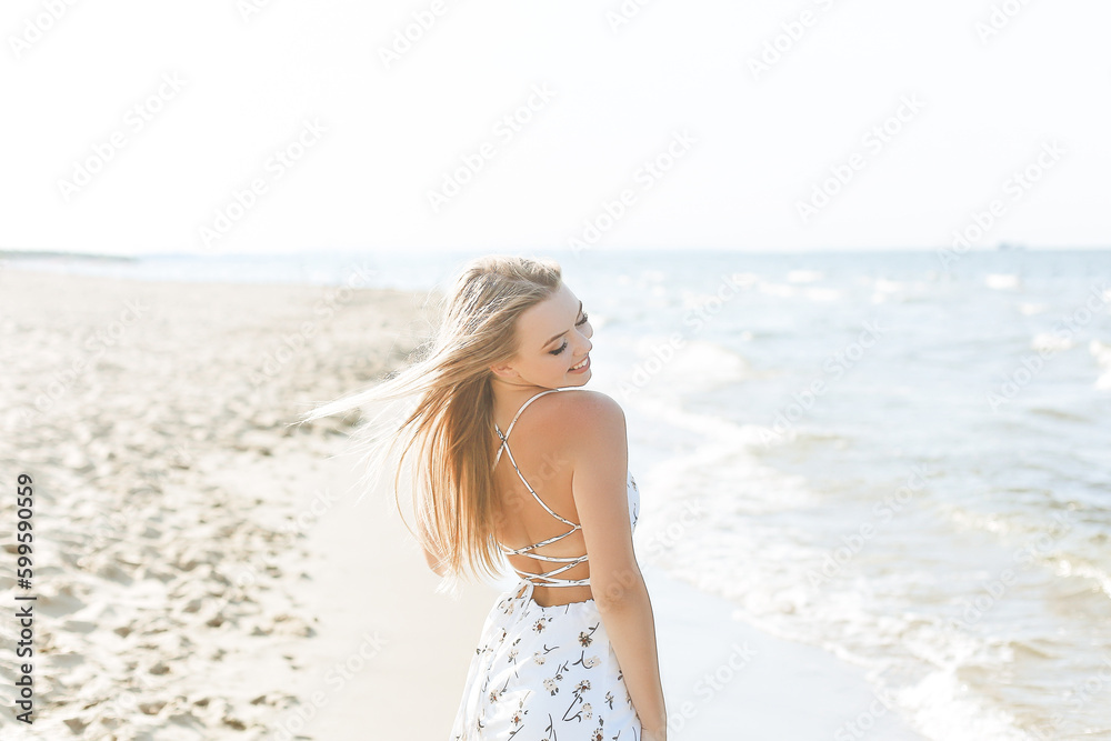 Happy blonde woman wearing sun glasses and relaxing on a wooden deck chair at the ocean beach Happy blonde woman wearing sun glasses and relaxing on a wooden deck chair at the ocean beach