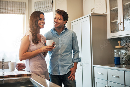 I love you like I love my coffee. a happy married couple chatting while drinking coffee together in their kitchen.