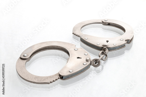 Quadro em tela Pair of steel handcuffs close up, Silver metal handcuffs on white