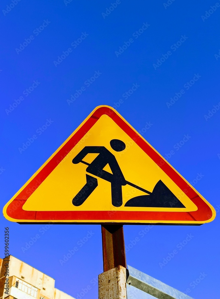 sign of a man digging with a shovel against a blue sky sign of a man digging with a shovel against a blue sky