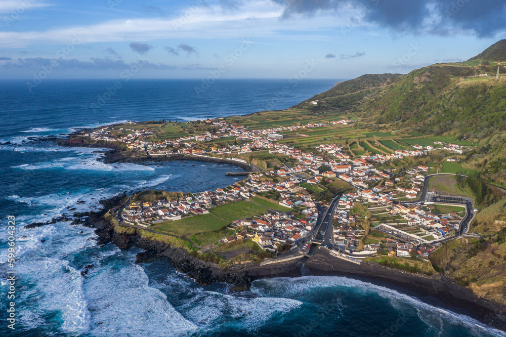 Aerial view of the coastline on Sao Miguel Island, with town buildings, green farmland and volcanic mountains, Azores, Portugal