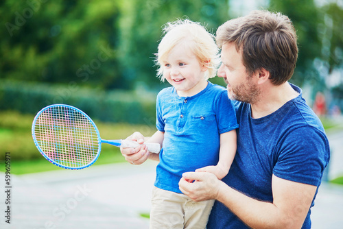 Little boy playing badminton with dad on the playground © Ekaterina Pokrovsky