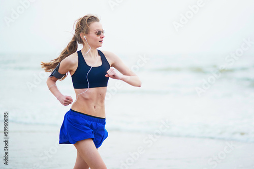 Young fitness running woman jogging on beach © Ekaterina Pokrovsky