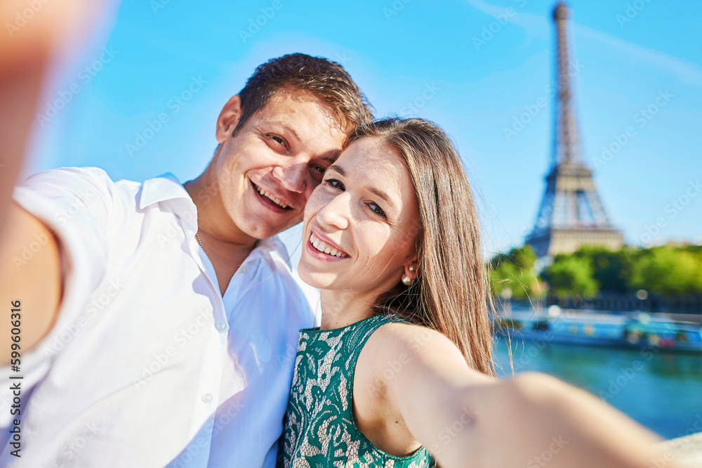 Romantic couple taking selfie near the Eiffel tower in Paris