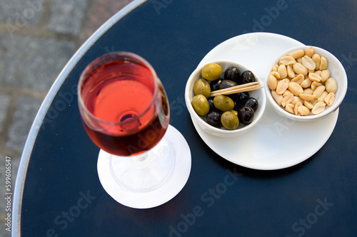 Parisian street cafe table with traditional French aperitif kir cassis and nibbles. Focus on nibbles