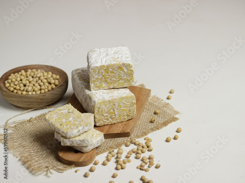 Raw Tempeh or Tempe. Tempeh Slices on Wooden White Background. Tempe Made From Fermented Soybeans