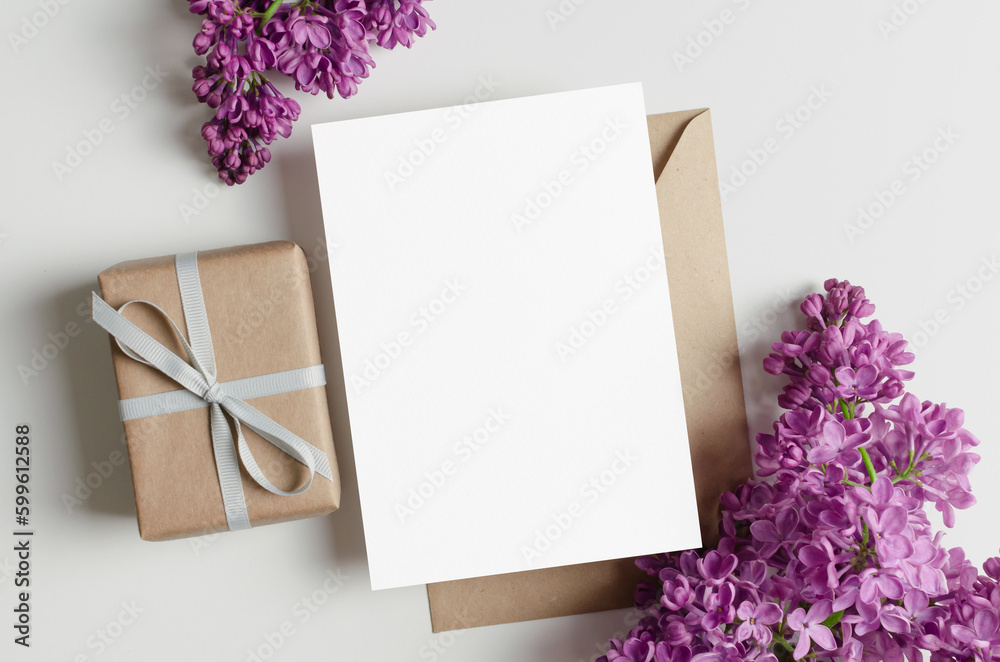 Blank greeting card mockup with gift box and lilac flowers, flat lay card with copy space Blank greeting card mockup with gift box and lilac flowers, flat lay card with copy space