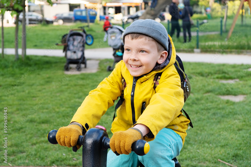 Boy on exercise bike in street playground.. Boy on exercise bike in street playground..