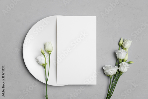 Wedding menu card mockup on white plate with eustoma flowers, blank mockup with copy space