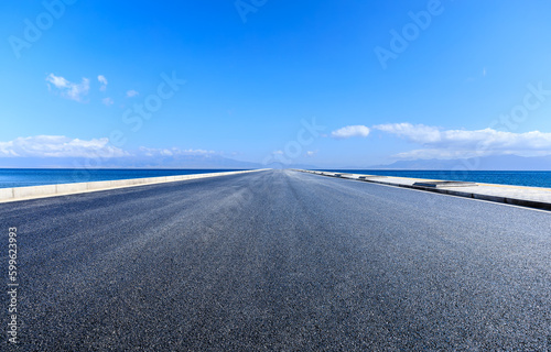Asphalt road and lake with sky cloud background © ABCDstock