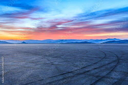 Asphalt road and mountains with beautiful sky clouds at sunrise