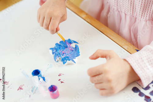 Child's Hands Painting with Colorful Brushes