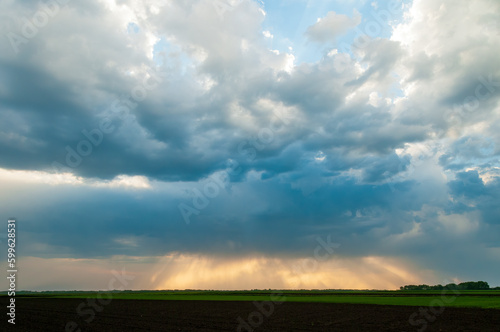 Cloudy stormy sky with sun rays