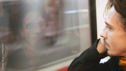 lonely pensive man in subway looks out window, an underground train, flow of life, time passes, slow motion. photo