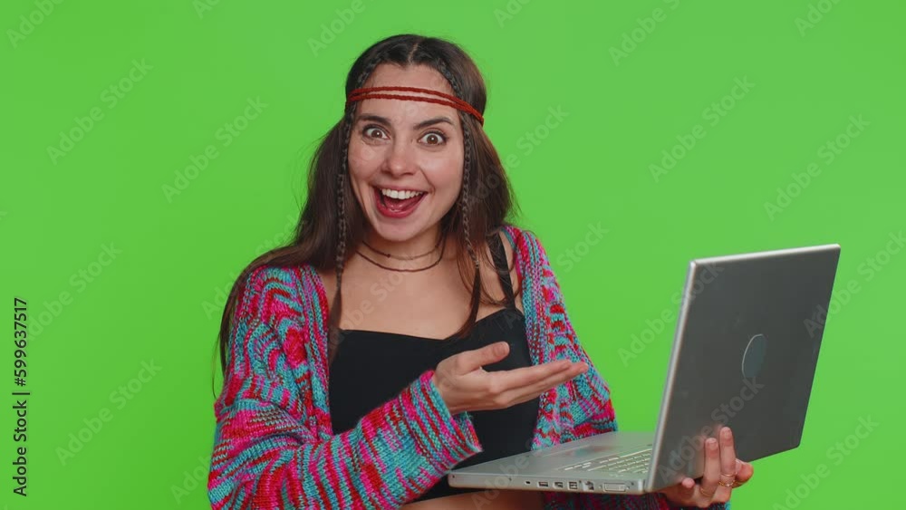 Excited happy young hippie woman typing on laptop computer, working on project, enjoying results, winning lottery, celebrating success online shopping win. Girl isolated on green chroma key background Excited happy young hippie woman typing on laptop computer, working on project, enjoying results, winning lottery, celebrating success online shopping win. Girl isolated on green chroma key background
