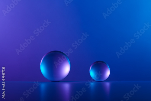 Two orbs or glass spheres on a blue and purple background. Clean an abstract geometric design with a modern feel.