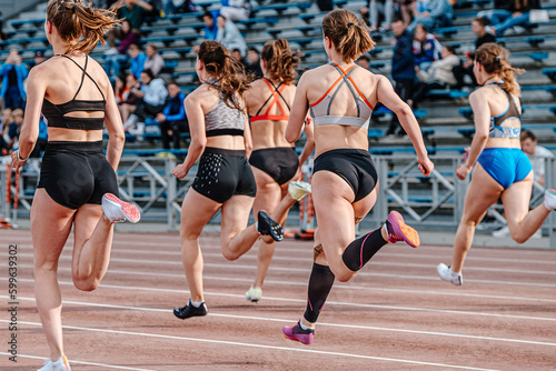 rear view group female athlete runners running sprint race, summer athletics championships