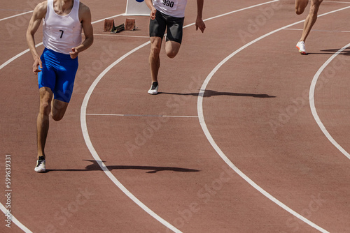 three male athlete runners starting running sprint race, summer athletics championships