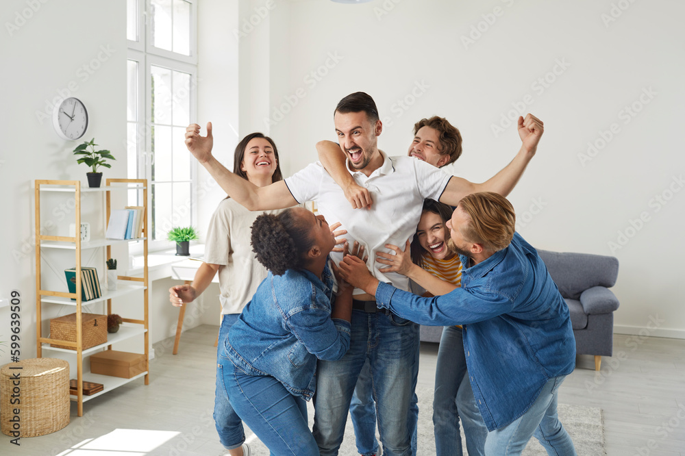 © Studio Romantic - Group excited young people congratulate friend man who's achieved great success. He standing in winner pose gesturing yes. They are cuddling him from all sides. Friendship, lifelong friends concept. © Studio Romantic - Group excited young people congratulate friend man who's achieved great success. He standing in winner pose gesturing yes. They are cuddling him from all sides. Friendship, lifelong friends concept.