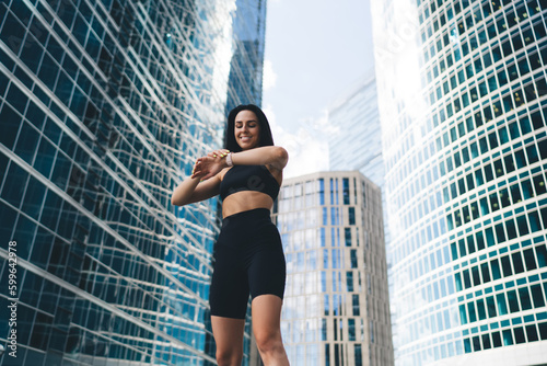 Cheerful fit lady with smart watch in city center