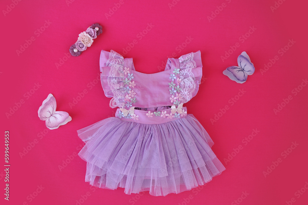 vestido de bebê com borboleta ao redor em fundo rosa vestido de bebê com borboleta ao redor em fundo rosa
