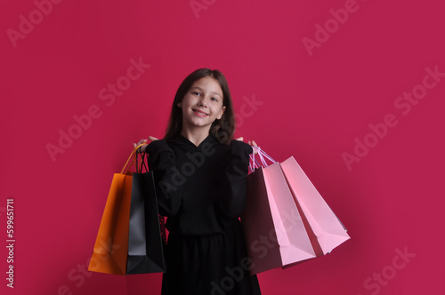 criança menina feliz com as sacolas de compras e presentes